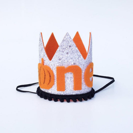White Glitter “one” birthday crown with orange and black detail.